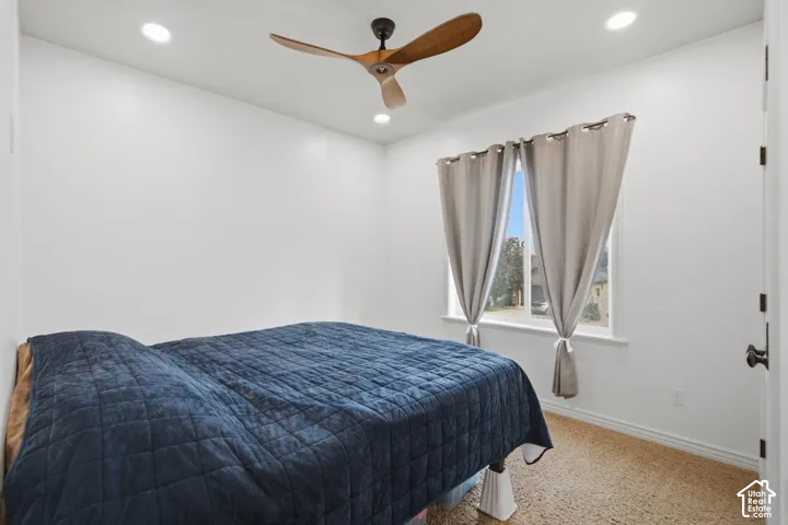 Bright interior space featuring a window with natural light, recessed lighting, and a ceiling fan with wooden blades