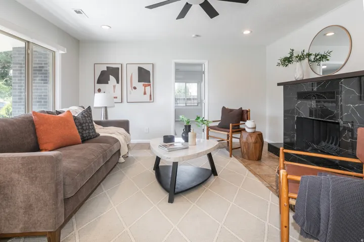 Living area featuring a black marble-style fireplace, recessed lighting, and a ceiling fan