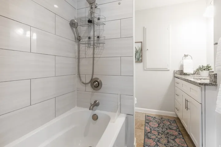 White subway tile bath surround with a multi-function showerhead and brushed nickel fixtures