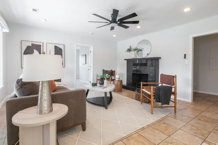 Living area featuring a black marble-patterned fireplace, recessed lighting, and a ceiling fan