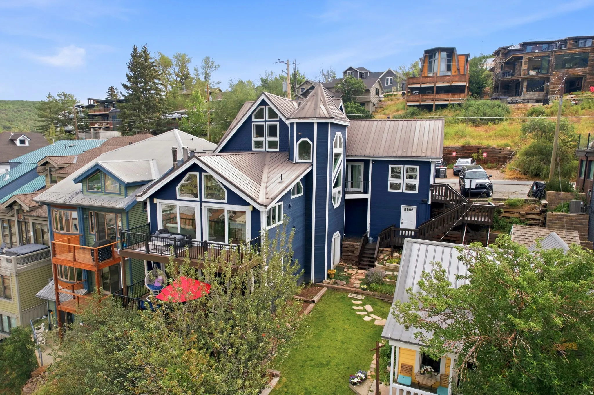 Blue-sided multi-level home featuring a prominent turret and multiple gabled roofs