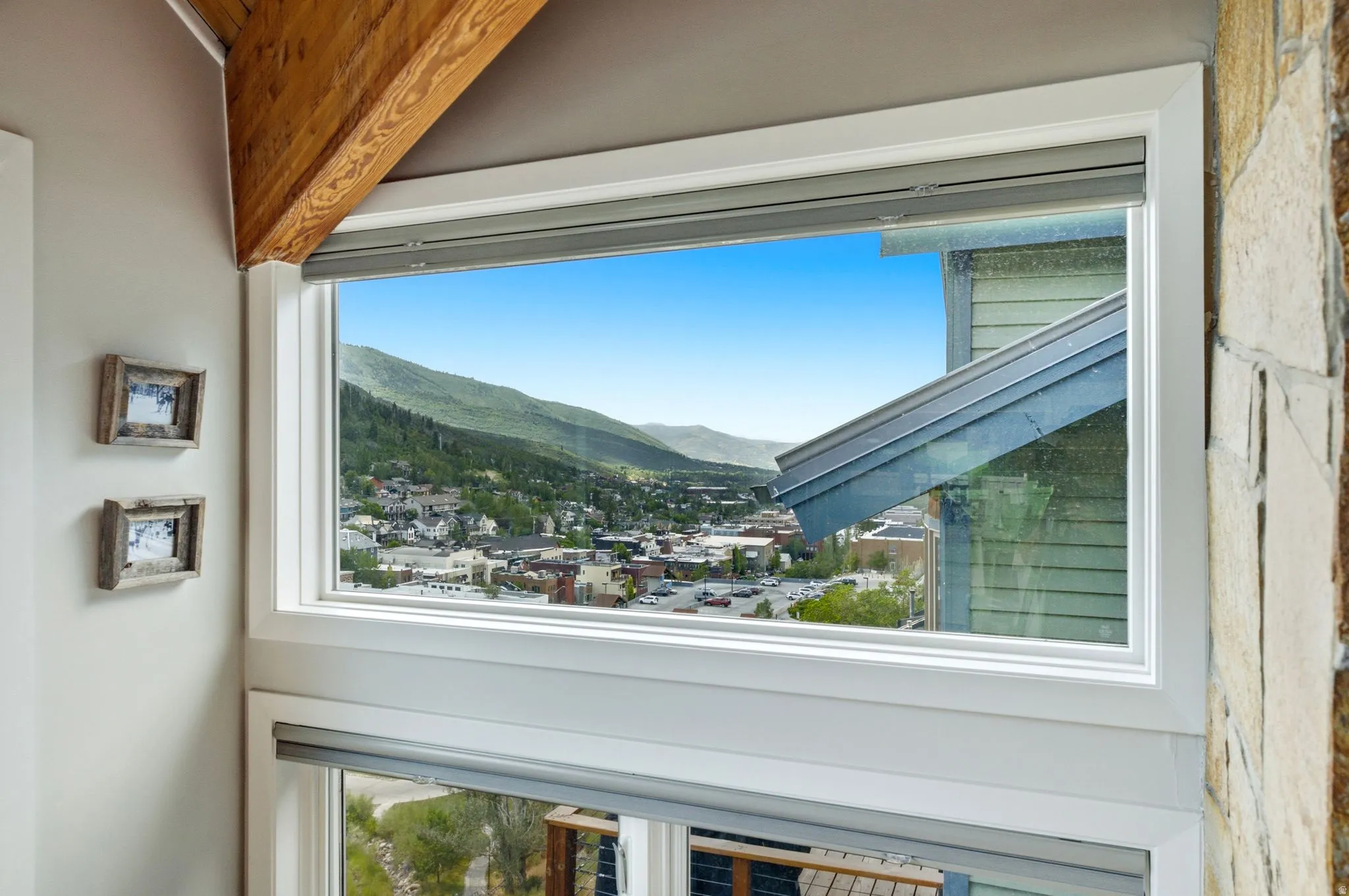 Large window with integrated blinds showcasing distant town and mountain scenery