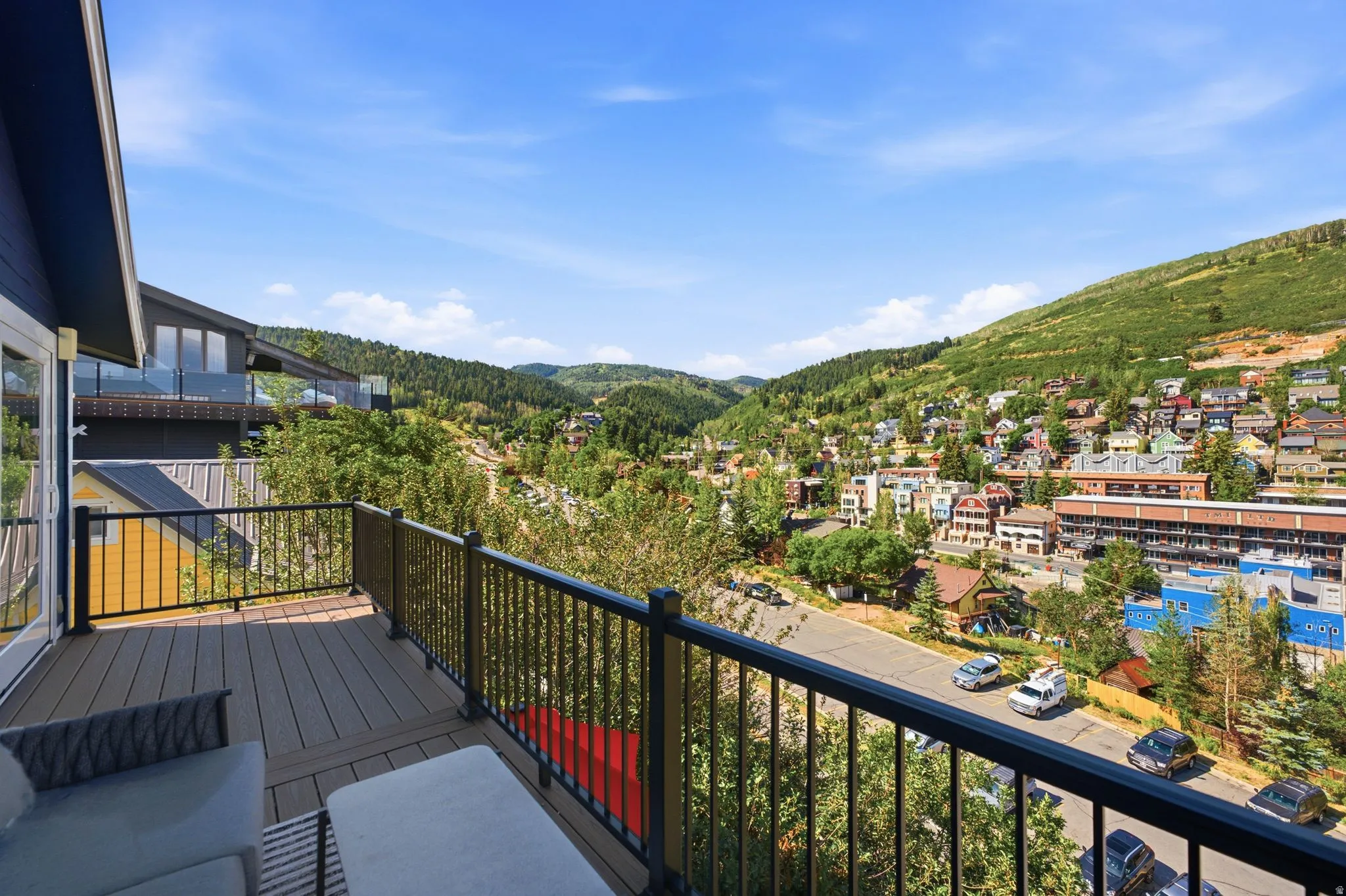 Expansive exterior balcony featuring composite decking and a black metal railing