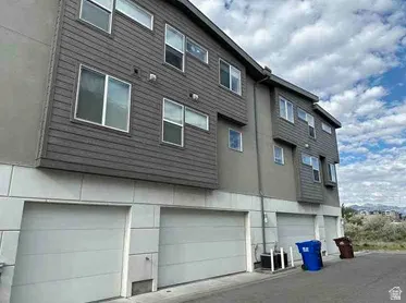 Modern multi-level exterior featuring grey horizontal siding and light-colored paneling