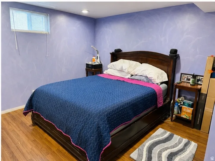 Spacious room featuring wood-finish flooring, recessed lighting, and a window with blinds
