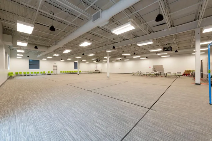 Expansive open-plan space featuring high ceilings with exposed ductwork and structural beams