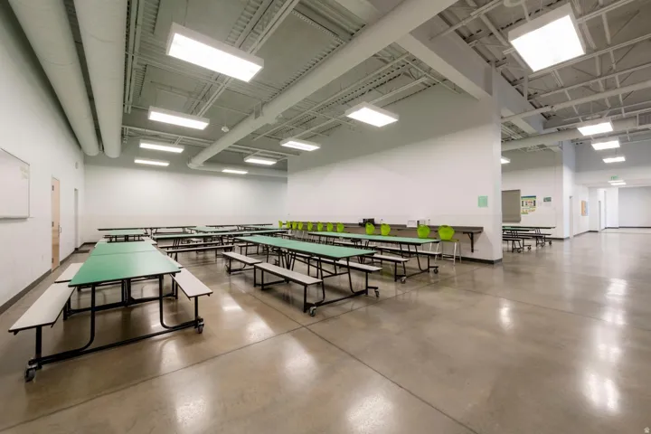 Spacious interior featuring polished concrete flooring and an exposed ceiling with extensive ductwork