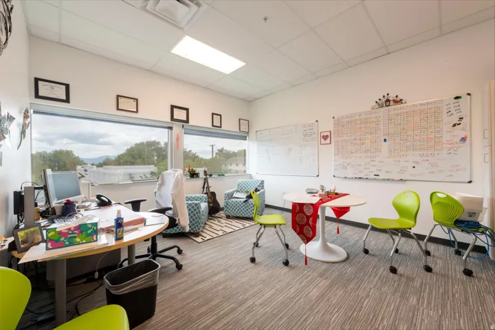 Bright interior space featuring expansive windows, wood-finish flooring, white walls, recessed lighting, and a drop ceiling