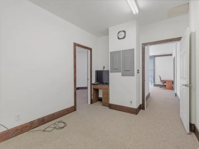 Carpeted interior space with white walls and dark wood-finish trim