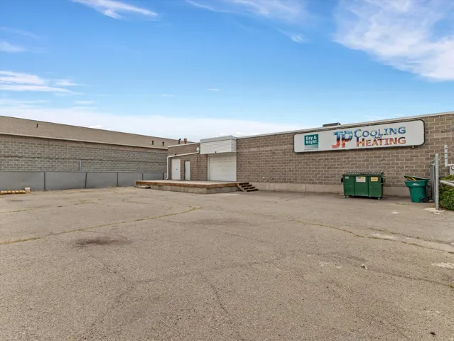 Commercial exterior featuring a paved surface, block construction, and a loading dock with two access doors