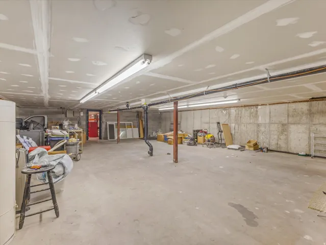 Expansive unfinished basement featuring concrete block walls and a concrete floor