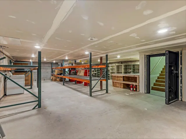 Spacious basement storage area featuring concrete flooring and exposed ceiling with recessed lighting