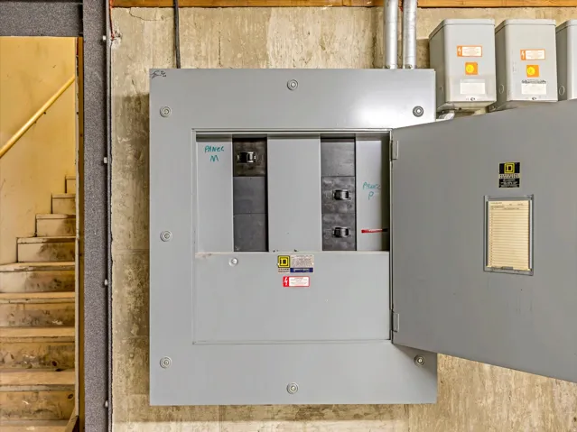 Electrical panel with an open door revealing circuit breakers