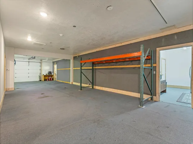 Expansive interior space featuring gray carpet flooring and recessed lighting