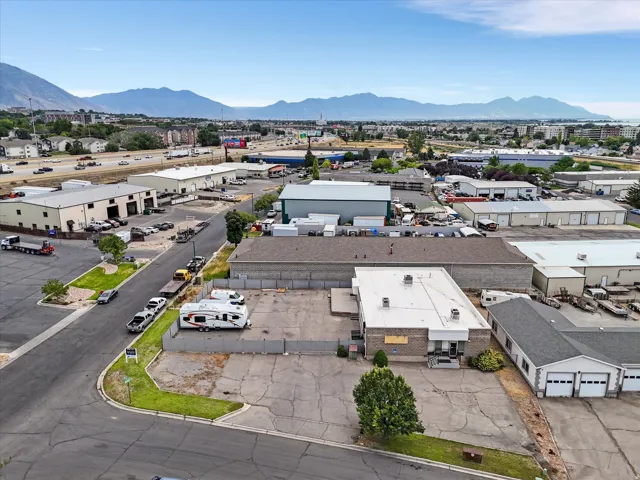 Industrial property featuring a main building with a flat roof and a secondary building with multiple garage doors