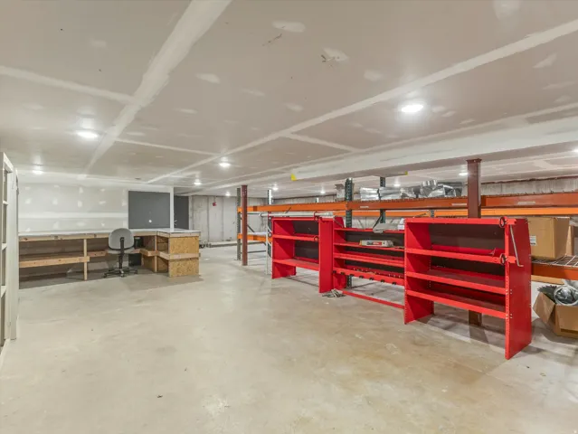 Large unfinished space featuring concrete flooring, exposed structural beams, and recessed ceiling lighting