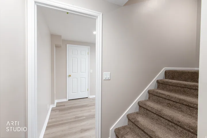 Interior doorway revealing a hallway with light wood-finish flooring