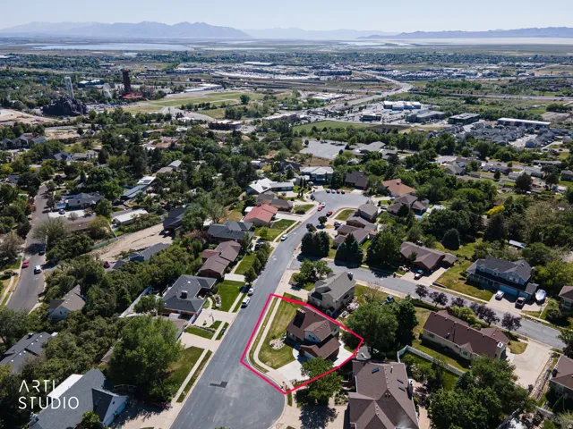 Aerial perspective showcasing a residential neighborhood with a distant body of water and mountains