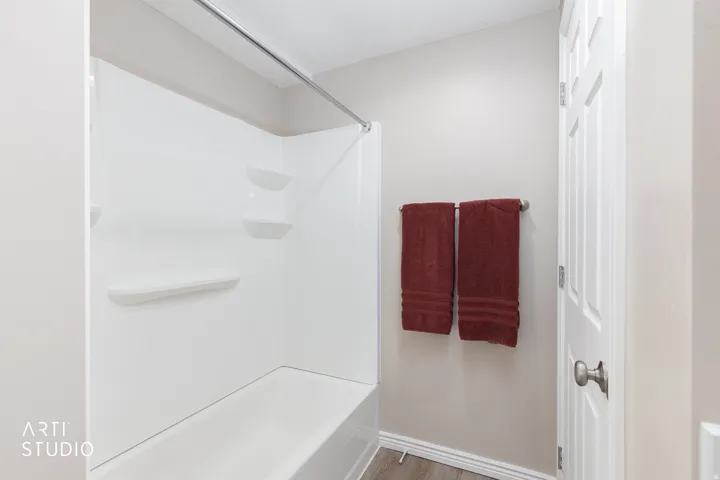 White bathtub and shower surround with integrated shelving