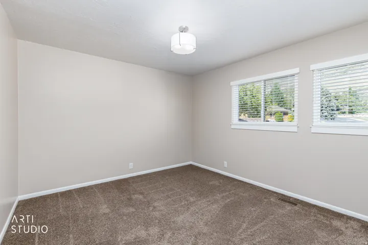 Neutral-toned walls complement the textured brown carpeting