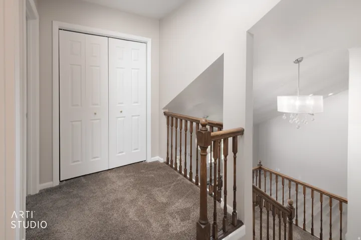 Upper level landing featuring neutral wall paint and plush gray carpet