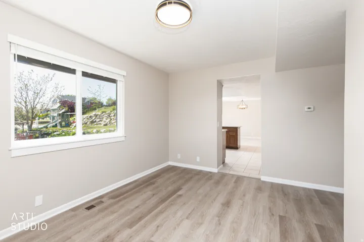 Living space featuring light wood-finish flooring, neutral wall paint, and white baseboards