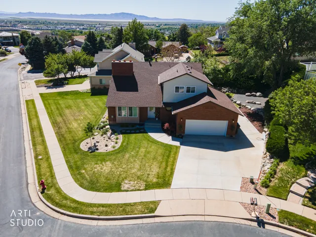 Traditional two-story residence featuring a two-car garage, mature landscaping, and a corner lot