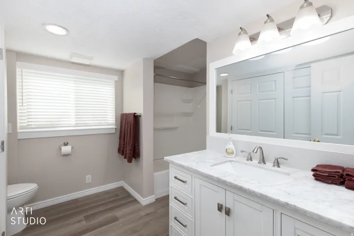 Bathroom featuring a vanity with a rectangular undermount sink, a white countertop, and a large framed mirror