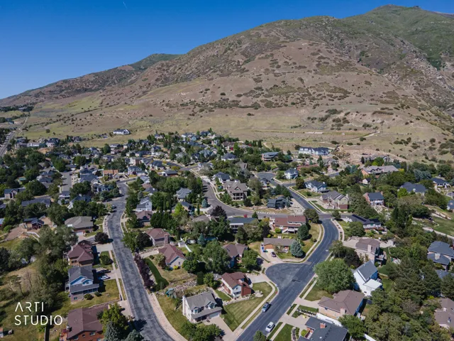 Residential neighborhood situated against a mountainous backdrop with paved streets and mature landscaping