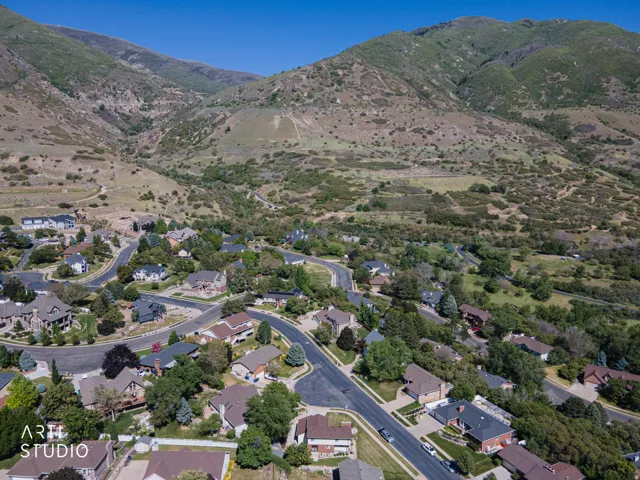 Community situated within a mountainous landscape, featuring residential properties with varying architectural styles
