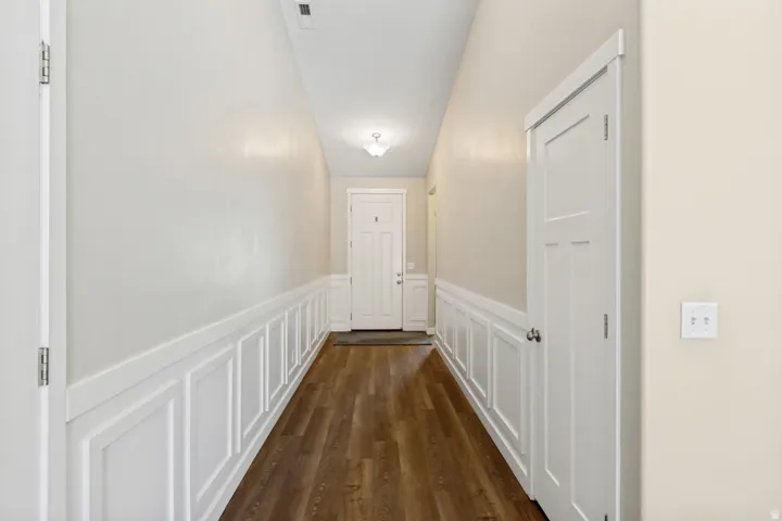 Entryway featuring wood-finish flooring, wainscoting, and a ceiling-mounted light fixture