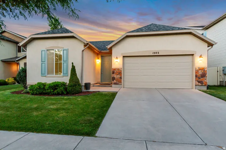 Stucco exterior with stone accents and a concrete driveway