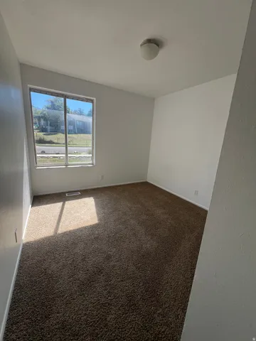 Wall-to-wall carpeting with a neutral finish, multiple wall outlets, and a flush-mount ceiling light