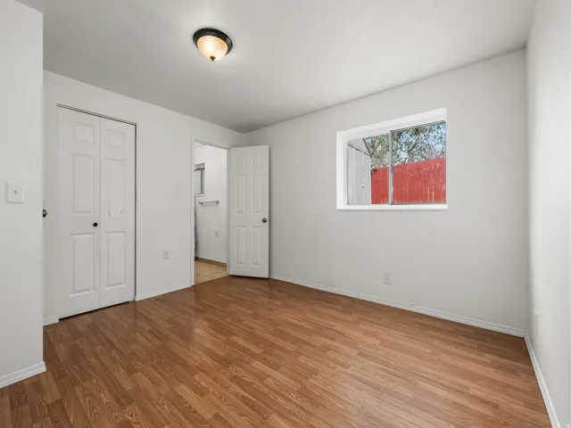 Room with wood-finish flooring, a window offering natural light, and a ceiling-mounted light fixture