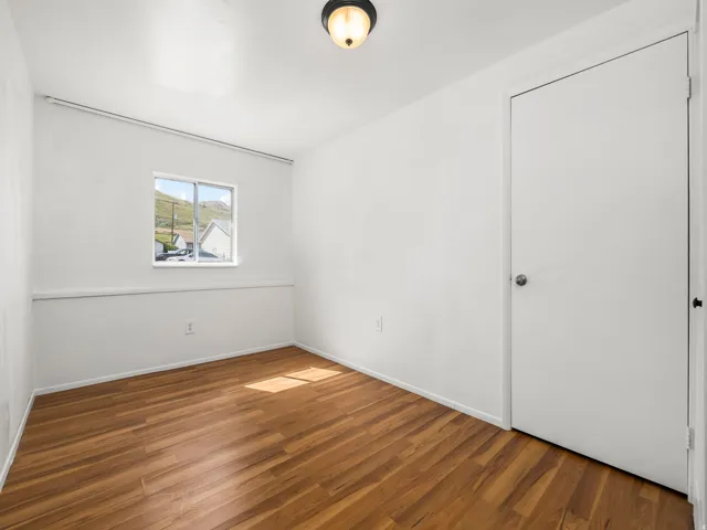Bright interior space featuring wood-finish flooring, white walls, and a ceiling-mounted light fixture