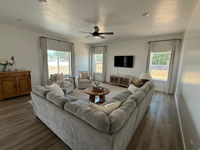 Spacious living area featuring wood-finish flooring, recessed lighting, and a ceiling fan