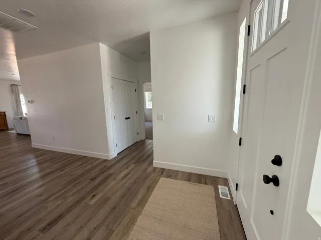 Entryway featuring a white paneled door with black hardware, complementing a neutral color palette