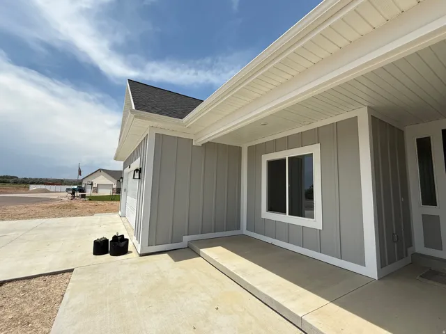 Modern exterior featuring light gray board and batten siding with white trim