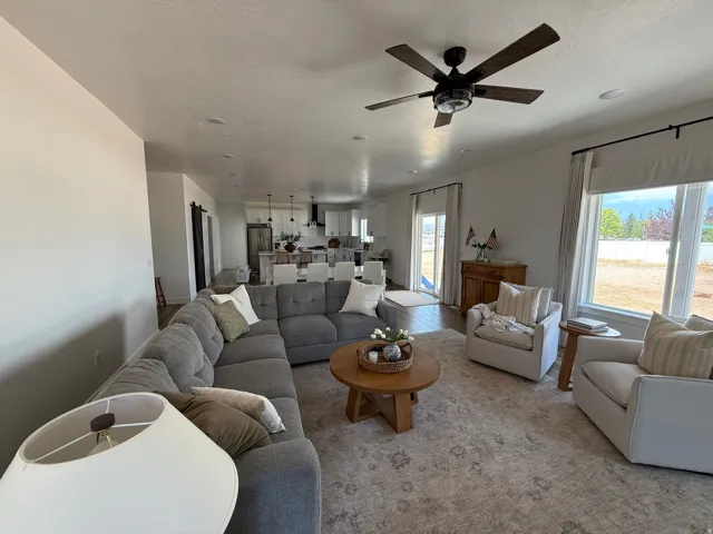 Spacious open-concept living area featuring wood-finish flooring, recessed lighting, and a ceiling fan