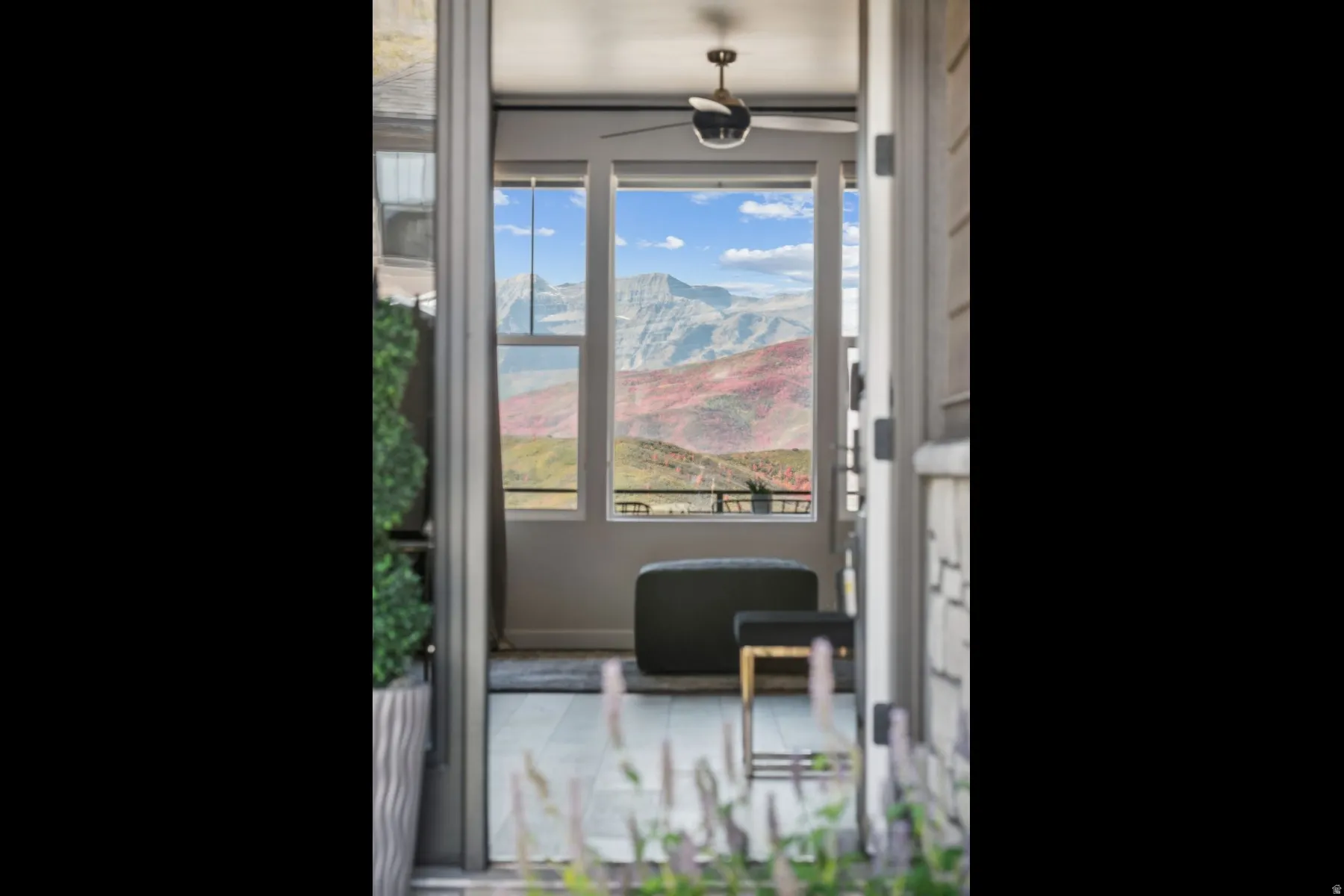 Covered patio featuring a ceiling fan, tiled flooring, and expansive mountain scenery
