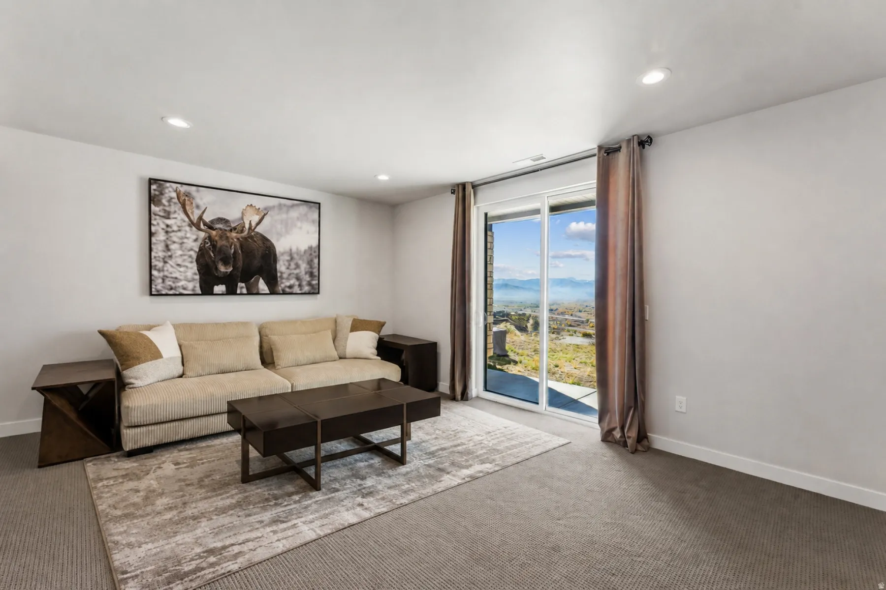 Spacious room featuring neutral carpeting, recessed ceiling lighting, and light-toned walls