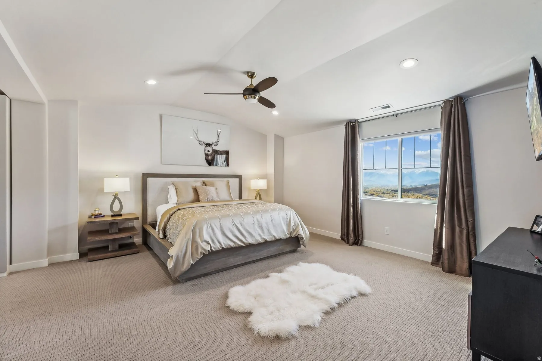 Carpeted bedroom featuring a large window with mountain scenery, recessed lighting, and a ceiling fan