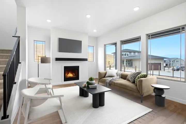 Living area featuring a fireplace with a black mantel, recessed lighting, large windows, and light wood-finish flooring