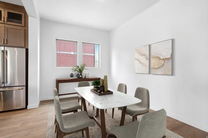 Bright dining area featuring wood-finish flooring and white walls