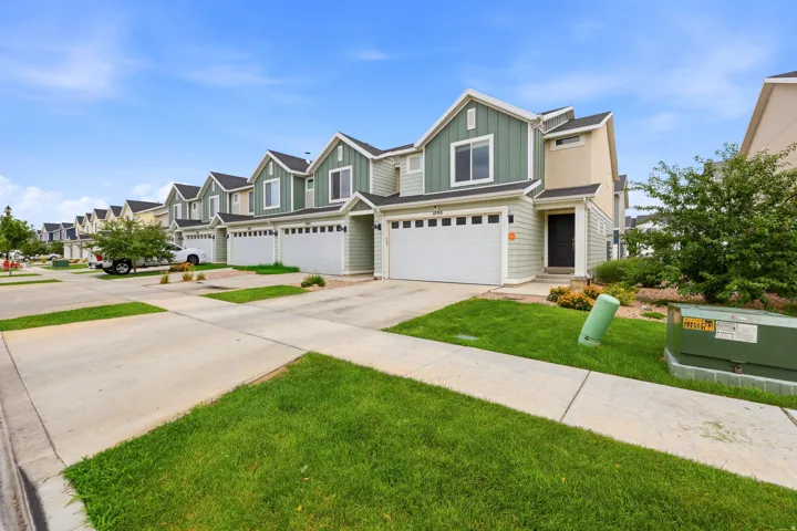 Contemporary townhome exterior featuring multi-toned siding, a two-car garage, and a covered entryway
