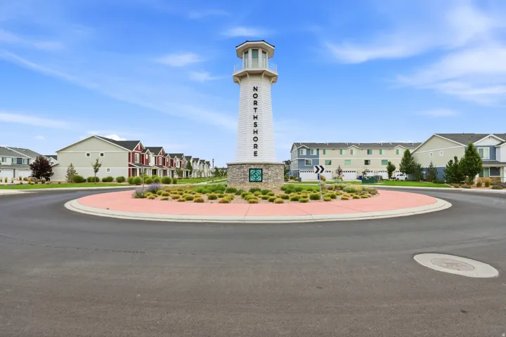 Central roundabout featuring a decorative lighthouse-inspired monument with "NORTHSHORE" lettering, surrounded by low-maintenance landscaping and red brick paving