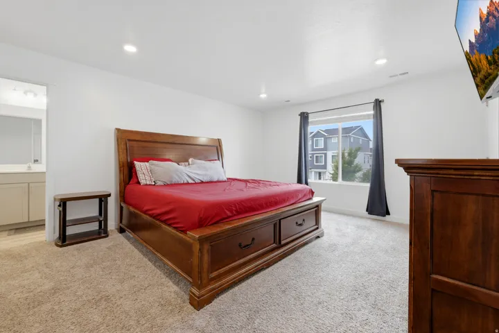 Spacious room featuring neutral carpet, recessed lighting, and a large window with privacy drapes