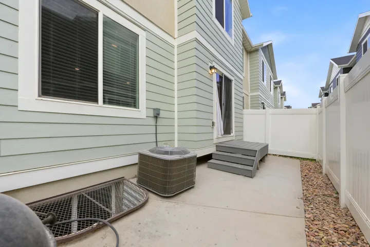 Private patio featuring concrete flooring, a multi-level composite deck, and white vinyl fencing