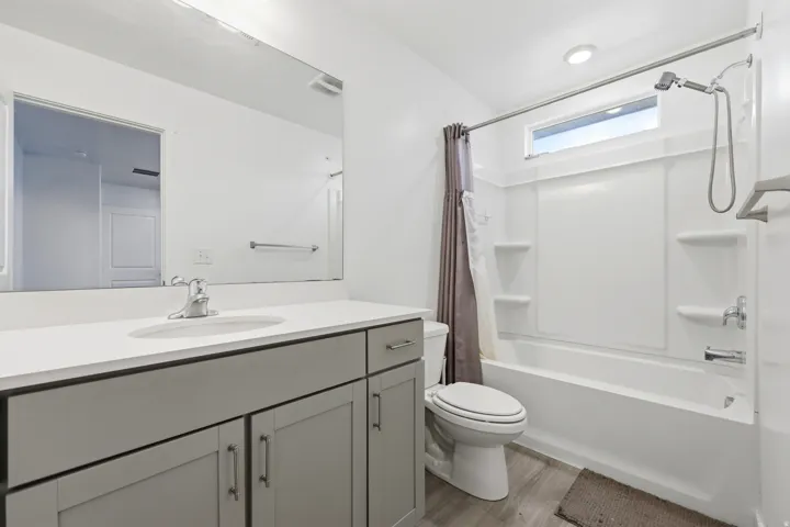Contemporary bathroom featuring a vanity with a light gray countertop, undermount sink, and gray cabinetry