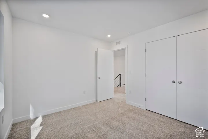 Neutral wall finishes, recessed lighting, wall-to-wall carpeting, and dual-panel interior doors
